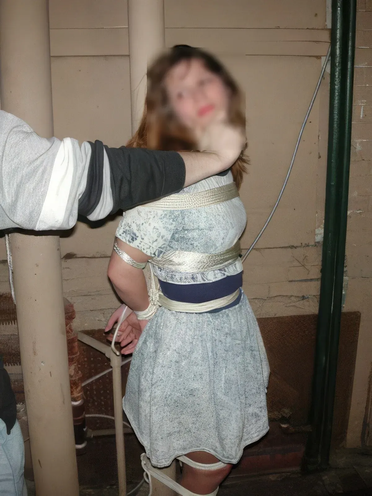 Blurred portrait of a person restrained with tape around the torso and legs, used with a review about privacy, consent, and community fit.