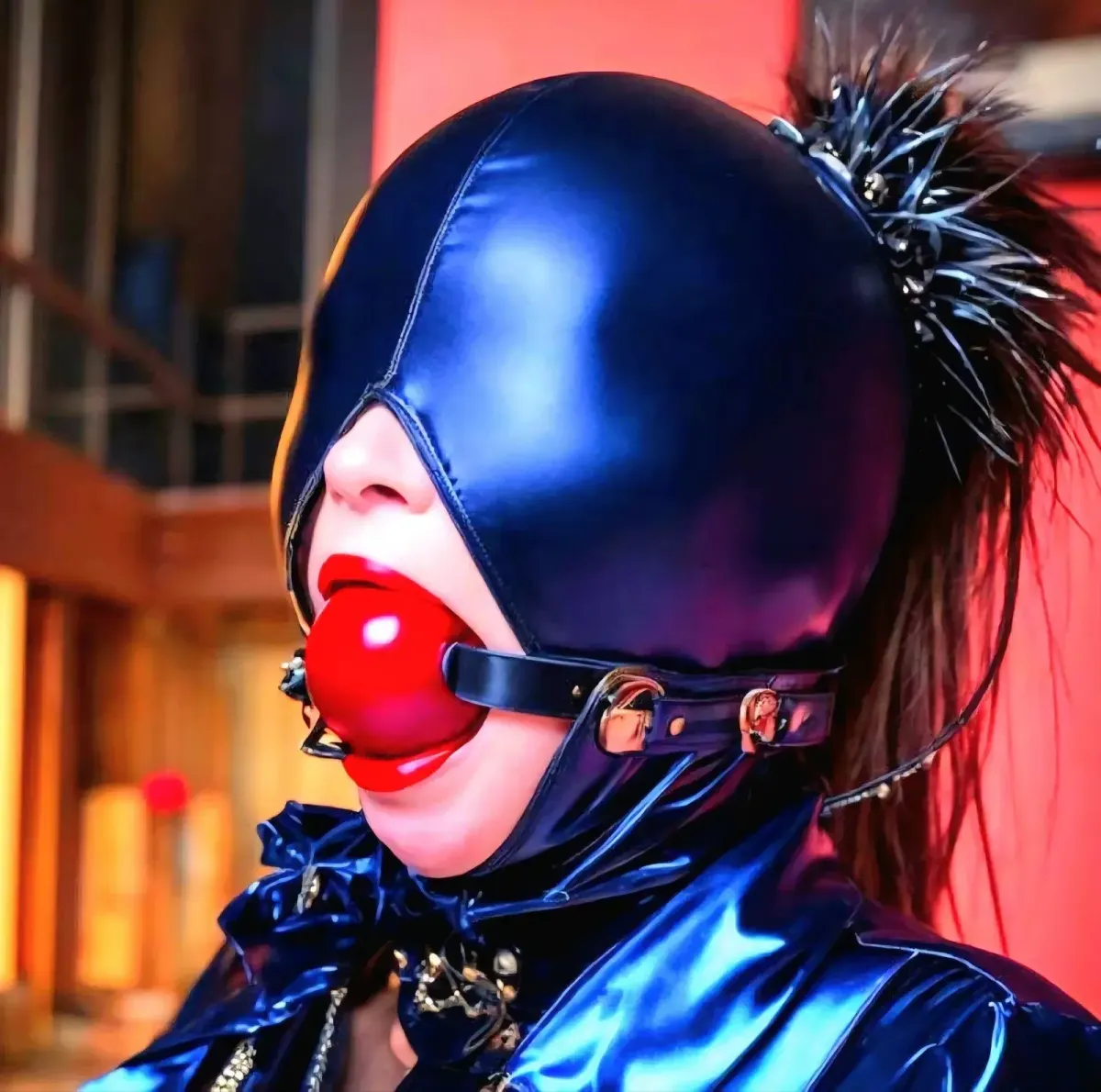 Side-profile close-up of a person in a shiny blue hood with a red gag ball, relevant to privacy considerations in kink dating. Side-profile close-up of a person in a shiny blue hood with a red gag ball, relevant to privacy considerations in kink dating.